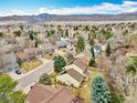 Scenic aerial view of a suburban neighborhood featuring a yellow home and stunning mountain range in the background at 10627 Chautauga Mtn, Littleton, CO 80127
