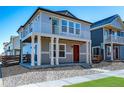 Attractive two-story home with gray siding, a red door and a balcony for enjoying neighborhood views at 46554 Avery Ln, Bennett, CO 80022