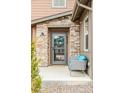 Inviting front porch features a decorative door, stylish sitting area, and stone accents for a cozy entrance at 8437 Mount Kataka Loop, Littleton, CO 80125