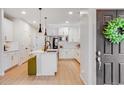 Modern kitchen boasts an island, white cabinets, stainless appliances, and stylish pendant lighting for a bright, airy space at 8437 Mount Kataka Loop, Littleton, CO 80125