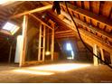 Exposed rafters and abundant sunlight fill the attic space, highlighting its potential for renovation at 241 W 4Th Ave, Denver, CO 80223