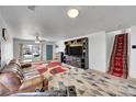 Open-concept living room with a unique patterned rug and stairway with patterned runner at 5214 Perth Ct, Denver, CO 80249