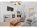 Open concept living room with tiled fireplace and a view into the adjacent kitchen area at 5899 S Taft Ter, Littleton, CO 80127