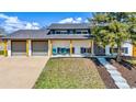 Charming exterior view of home with a large front yard, covered porch and two car garage at 7017 W 62Nd Pl, Arvada, CO 80003