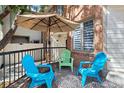 Cozy patio with bright blue seating and stylish geometric rug, shaded by a large umbrella at 152 S Jackson St, Denver, CO 80209