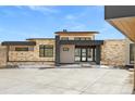 Stylish home exterior with stone cladding, large windows, and a concrete driveway at 545 Strada Rossa Rd, Golden, CO 80401