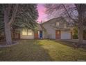 Charming two-story home featuring a manicured lawn and a welcoming blue front door at 1348 E Jamison Ave, Centennial, CO 80122