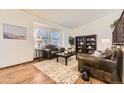 Cozy living room with hardwood floors, leather seating, decorative rug, and natural light from the window at 1348 E Jamison Ave, Centennial, CO 80122