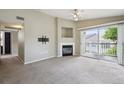 Inviting living room featuring a cozy fireplace, ceiling fan, and access to a balcony with a view at 8775 W Berry Ave # 203, Littleton, CO 80123