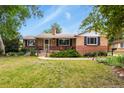 Charming brick home with a well-manicured lawn and mature trees in a desirable neighborhood at 4040 Cody St, Wheat Ridge, CO 80033