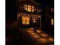 Charming two-story home featuring a cozy porch, balcony, and illuminated pathway for an inviting ambiance at 5027 N Walden Way, Denver, CO 80249