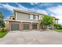 Townhouse exterior showcases attached garages and a combination of stone and siding at 6222 Kilmer Loop # 103, Golden, CO 80403