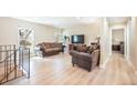 Sun-filled living room with hardwood flooring, comfortable seating, and a view into a bedroom at 15691 E Atlantic Cir, Aurora, CO 80013