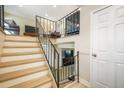 A wood and metal staircase leads to the upper level with neutral walls and white doors, with two lounge areas at 15691 E Atlantic Cir, Aurora, CO 80013