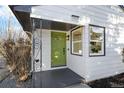 Close-up of the bright green front door and newly painted white exterior with dark trim at 5505 Brentwood St, Arvada, CO 80002