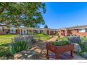 Charming red brick building with landscaped front lawn, inviting pathway, and colorful flowerbeds at 5425 County Rd 32 # 27, Mead, CO 80504