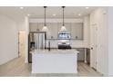 Modern kitchen boasts stainless steel appliances, gray cabinetry, and a center island with pendant lighting at 352 N. Geneva St, Aurora, CO 80010