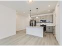 Well-lit kitchen with a center island, stainless steel appliances, and gray cabinets, creating an open and airy atmosphere at 352 N. Geneva St, Aurora, CO 80010