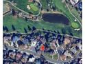 Aerial view of the property showcasing its location near a golf course, pond, and other neighborhood homes at 11351 Quivas Way, Denver, CO 80234