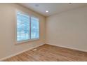 Bright bedroom featuring wood-look flooring and plantation shutters on the window at 22834 E Davies Dr, Aurora, CO 80016