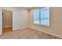 Bright bedroom featuring wood-look flooring and plantation shutters on the window at 22834 E Davies Dr, Aurora, CO 80016