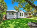 Charming single-story home featuring mature trees, manicured lawn, and tasteful landscaping at 5152 Bryant St, Denver, CO 80221