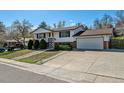 Charming two-story home with landscaped front yard and attached two-car garage on a sunny day at 13472 W Dakota Ave, Lakewood, CO 80228