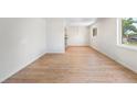 Bright living room with new wood floors, fresh white paint, and a view of the front yard at 9320 Fir Dr, Thornton, CO 80229