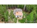 Aerial view of a quaint house nestled among lush green trees at 9092 Gray Ln, Conifer, CO 80433