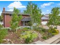 An inviting two-story brick home with lush landscaping and vibrant greenery enhancing its curb appeal at 2210 Miller St, Lakewood, CO 80215
