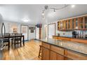 Bright kitchen features hardwood floors, island, stainless refrigerator, and a dining table with seating for four at 2210 Miller St, Lakewood, CO 80215