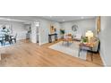 Open-concept living area with hardwood floors, and access to the kitchen at 1344 Sable Blvd, Aurora, CO 80011