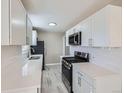 Contemporary kitchen featuring white cabinets, stainless steel appliances, and sleek countertops at 382 S Decatur St, Denver, CO 80219