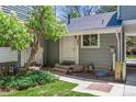 Charming front entrance of home with gray siding, a white door, and a small, well-maintained yard at 262 S Nome St, Aurora, CO 80012