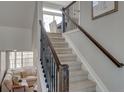 Carpeted staircase with modern railing leads to the upper level of this beautifully appointed home at 1188 Sugarloaf Ln, Erie, CO 80516