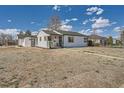 Quaint home exterior with a detached garage and mature trees at 851 S Umatilla Way, Denver, CO 80223