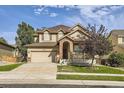 Charming two-story home with a well-manicured lawn, arched front porch, and attached two-car garage at 10288 Salida St, Commerce City, CO 80022