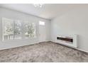 Cozy living room with plush carpeting, a modern fireplace, and bright windows at 10288 Salida St, Commerce City, CO 80022