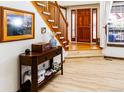 Inviting foyer with hardwood floors, staircase, and natural light from the sidelight windows at 17020 W 64Th Dr, Arvada, CO 80007