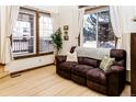 Cozy living room featuring large windows, hardwood floors, and a comfortable couch for relaxation at 17020 W 64Th Dr, Arvada, CO 80007