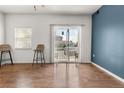 Bright living room with hardwood floors, blue accent wall, and sliding glass door leading to outdoor area at 1771 W 53Rd Pl # 1, Denver, CO 80221
