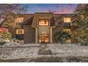 Charming building exterior with beautiful sunset view and landscaped snow covered yard at 7755 E Quincy Ave # 301A2, Denver, CO 80237