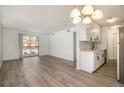 Bright living room features updated flooring, a sliding glass door and access to the kitchen at 7755 E Quincy Ave # 301A2, Denver, CO 80237