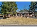 Well-maintained brick home with mature trees and a nicely landscaped front yard at 3860 S Elkhart St, Aurora, CO 80014