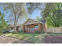 Charming brick bungalow with a welcoming front porch and well-maintained lawn at 2836 Cherry St, Denver, CO 80207