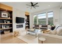 Bright living room with a modern fireplace, built-in shelves and large windows showcasing the outdoors at 3436 W 154Th Ave, Broomfield, CO 80023