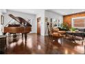Inviting living room with a piano, hardwood floors, and exposed brick for a warm and stylish ambiance at 449 S Humboldt St, Denver, CO 80209