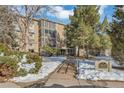 Well-maintained building exterior with mature trees and landscaping, sidewalk leading to front entrance at 13635 E Bates Ave # 406, Aurora, CO 80014