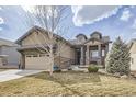 Attractive home featuring a manicured lawn, a two-car garage, and a lovely stone-accented front porch at 15831 Lavender Pl, Broomfield, CO 80023