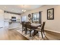 Dining room with wooden table and chairs, with an adjacent modern kitchen at 12749 Horton Ct, Parker, CO 80134